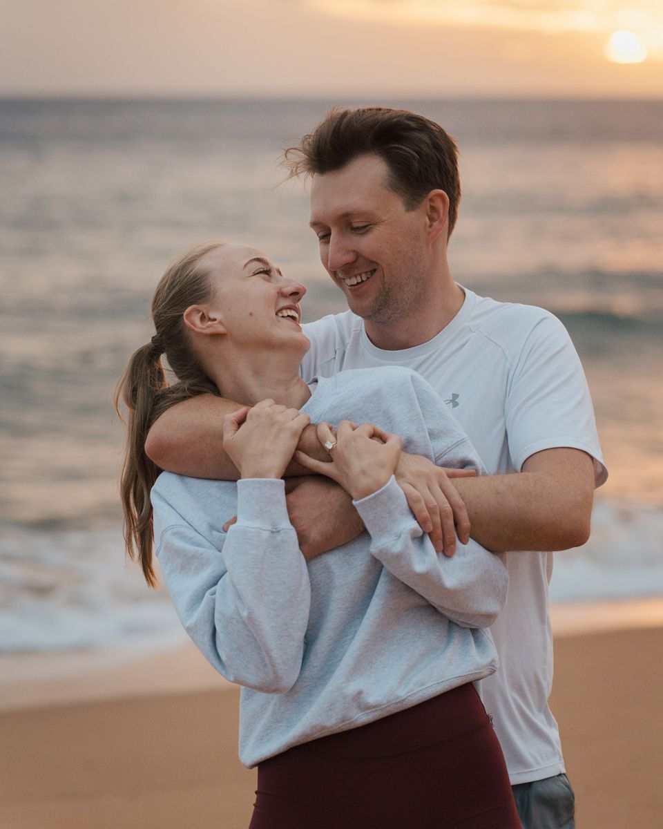 A couple shares a romantic moment during sunrise at Newport beach during secret proposal photoshoot in sydney northern beaches