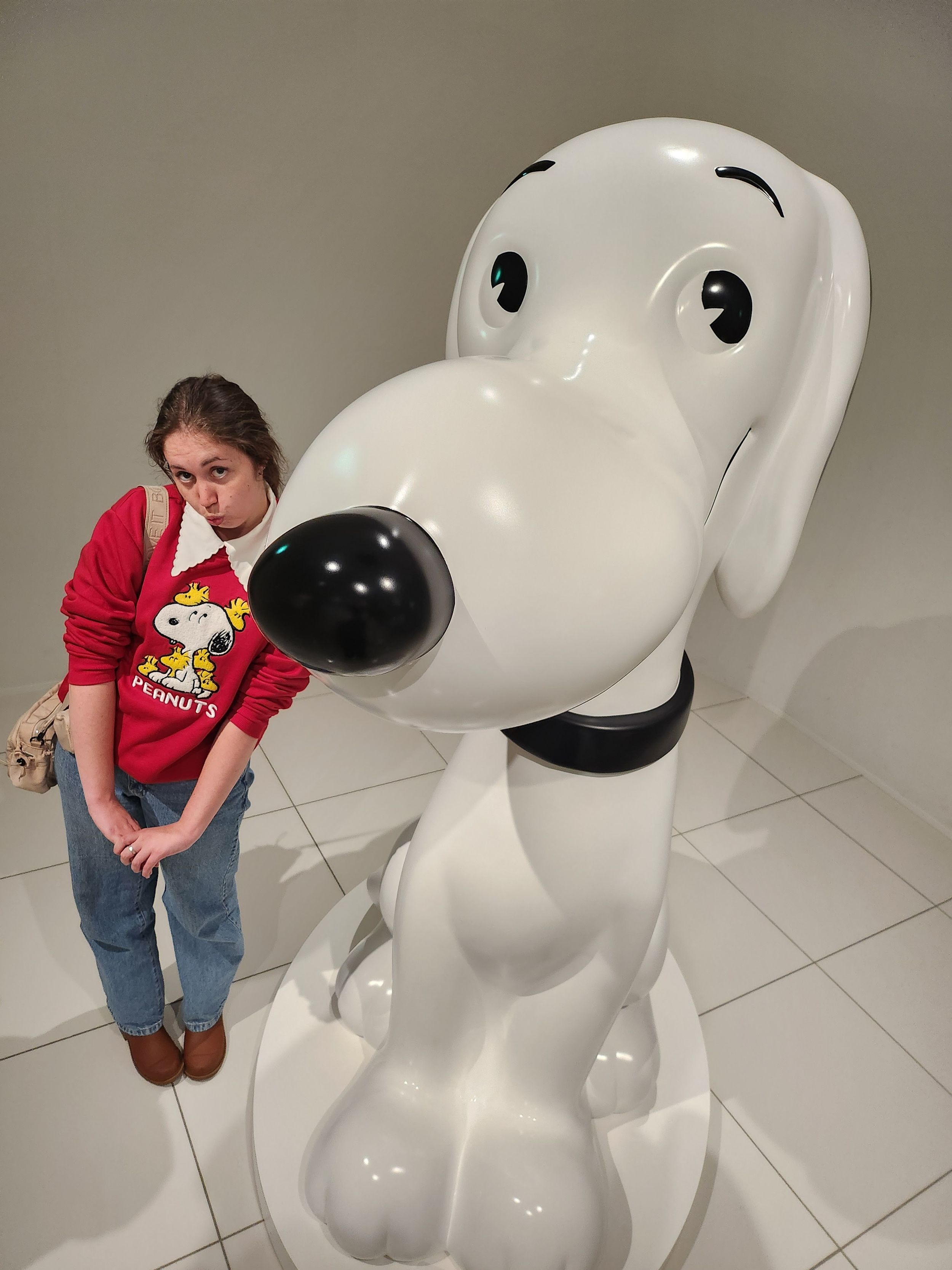 A series of photos showing a large white Snoopy statue display in what appears to be a shopping mall or public space.