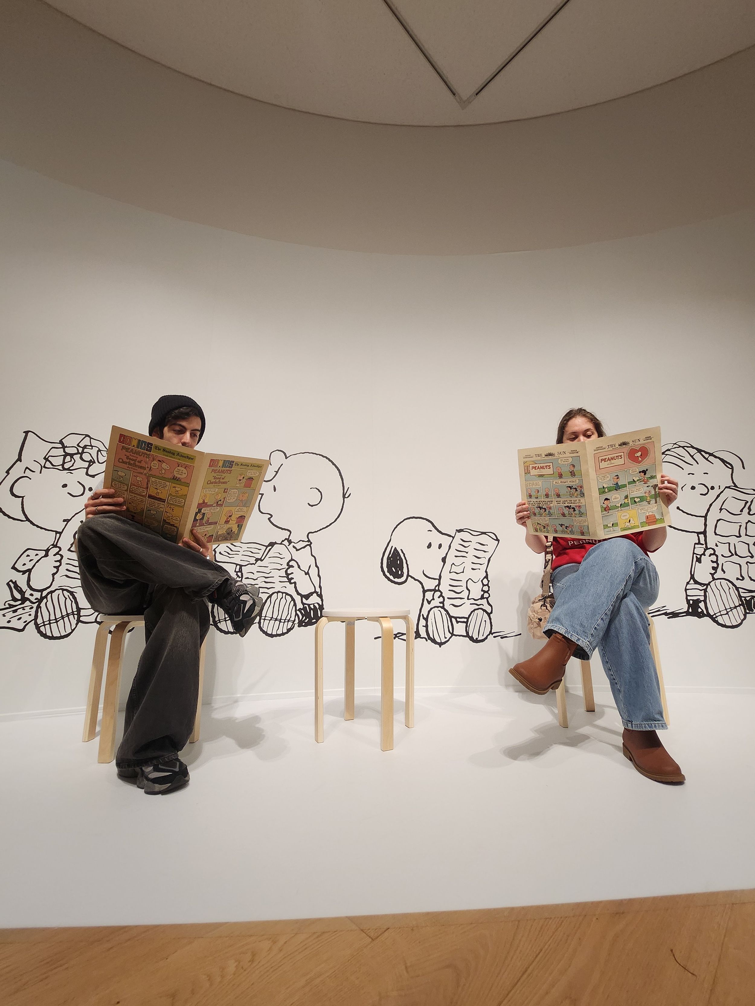A creative wall installation shows a sequence of line drawings with chairs arranged to create an illusion of movement.