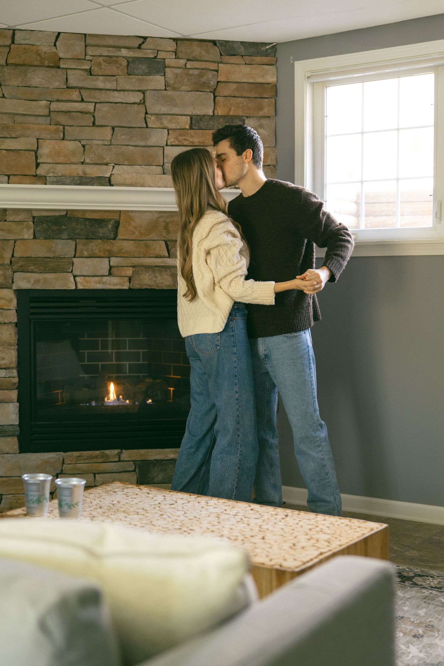 couple dancing in basement living room by fire