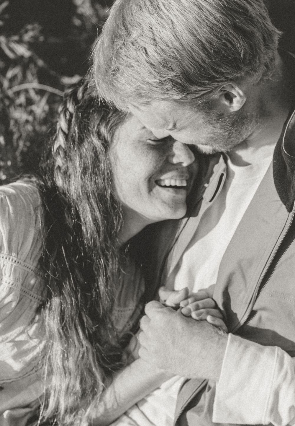 Black and white romantic photograph showing an intimate embrace between two people.