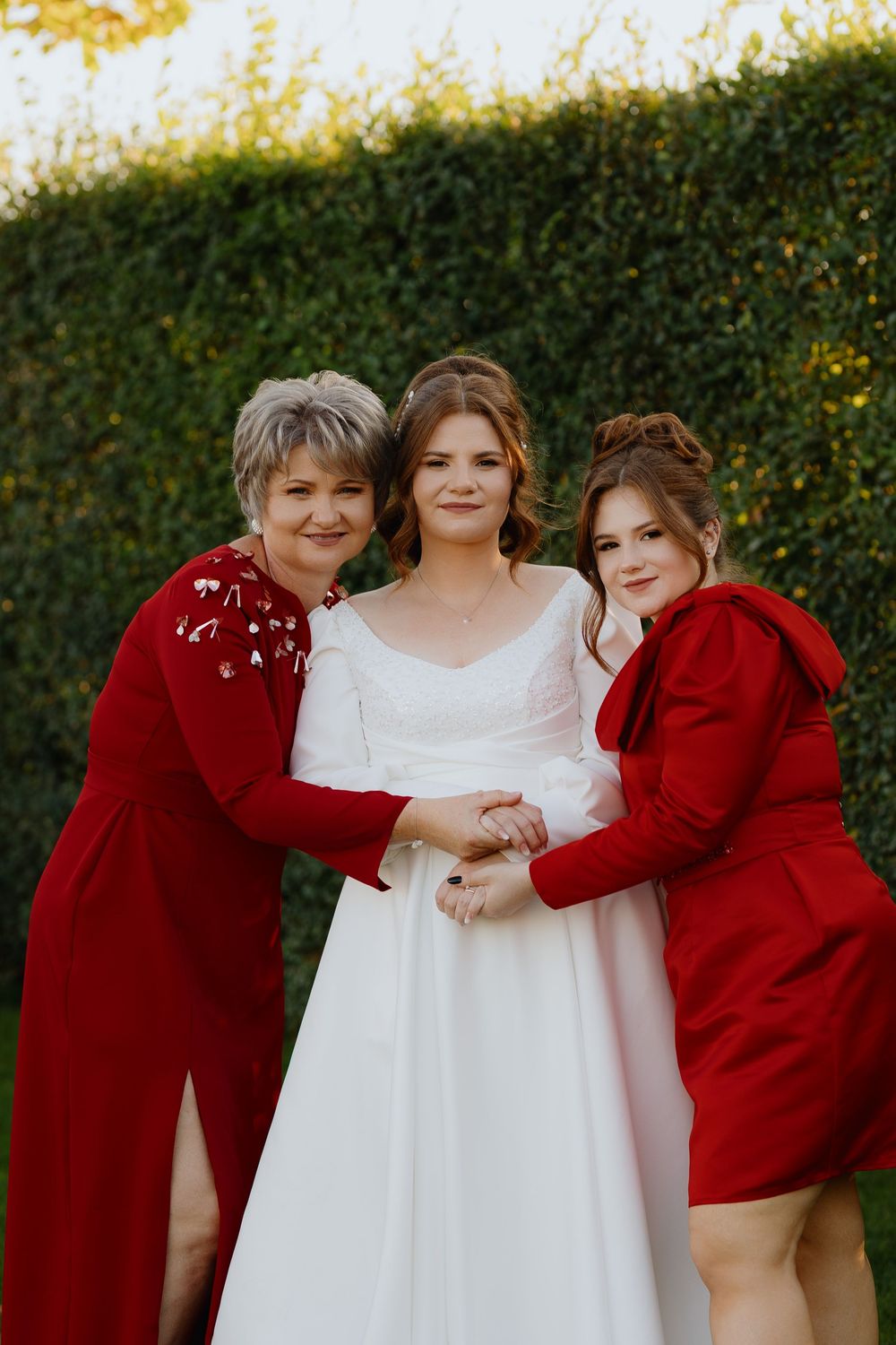 A group photo showing white and red outfits against a natural outdoor background with autumn foliage.