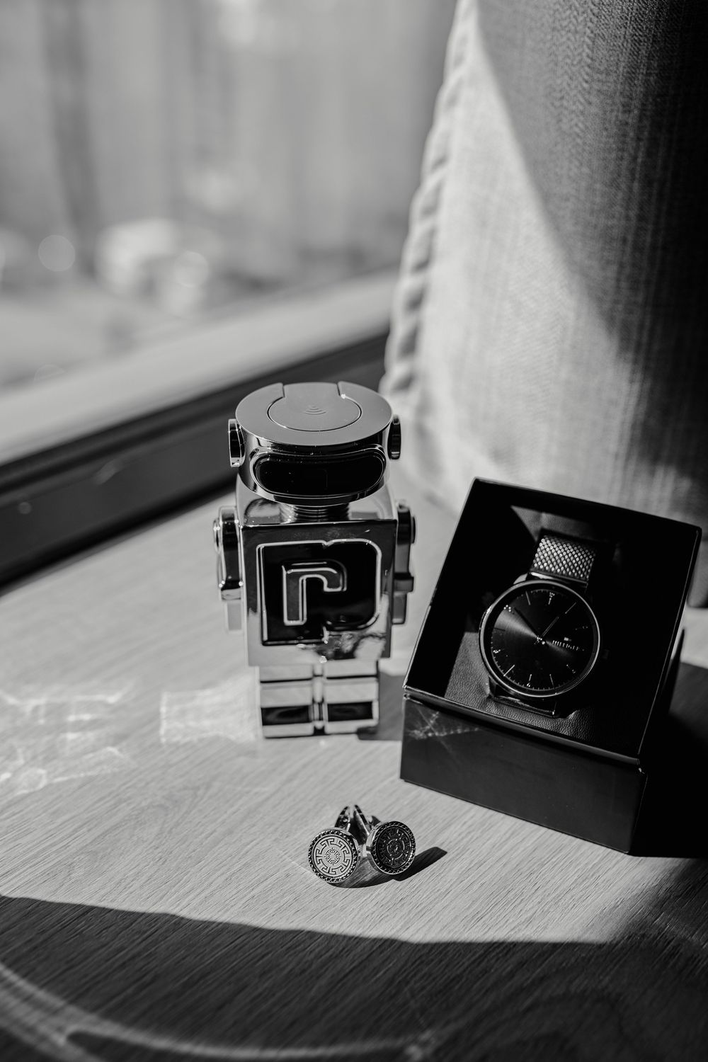 Black and white still life photos of a vintage camera on a wooden surface in dramatic lighting.