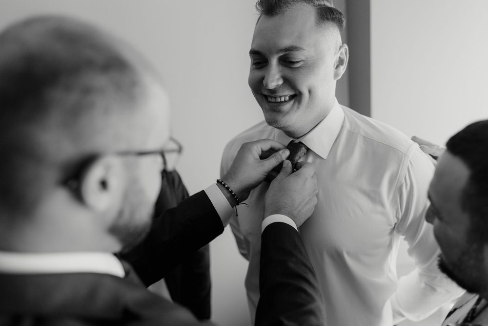 A series of black and white candid shots showing people laughing and interacting at a social gathering.