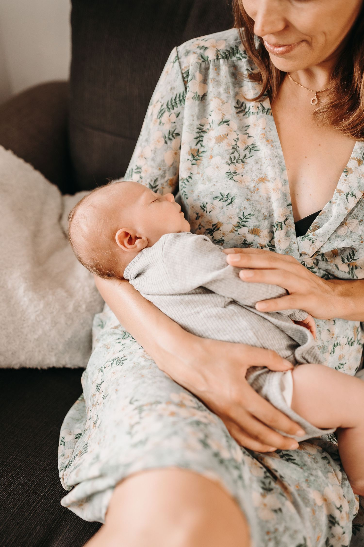 Séance photo bébé en Alsace, le bébé dort dans les bras de sa maman.
