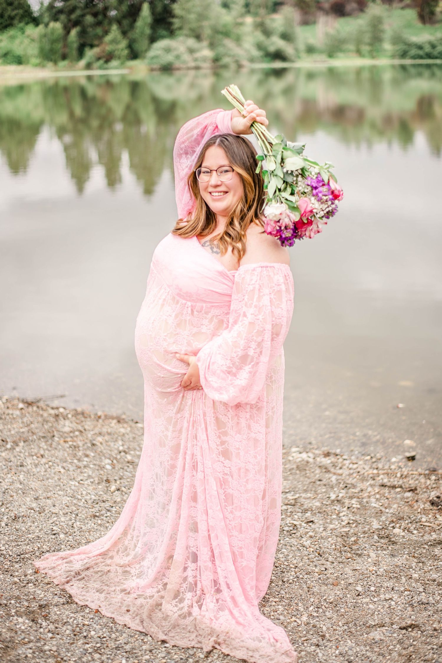 Pink lace dress photographed against a serene lake backdrop with natural lighting.