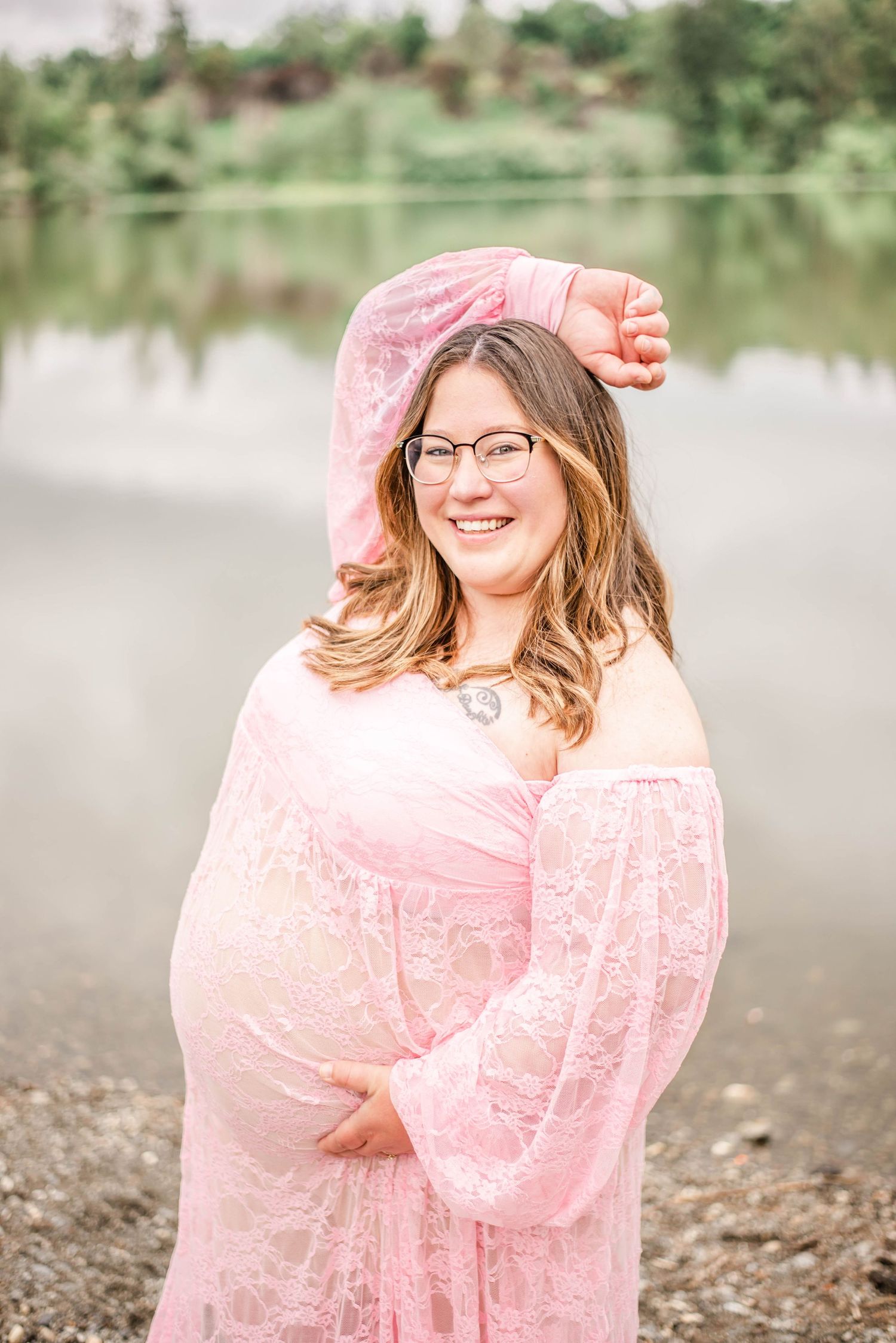 Whimsical outdoor portrait series with flowing pink lace dress by a misty waterfront.