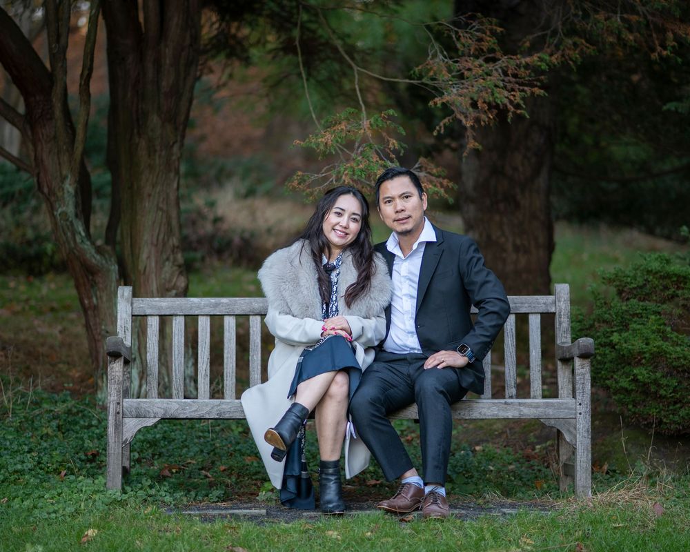 Couple portrait of woman and man sitting on bench in Holmdel Park NJ