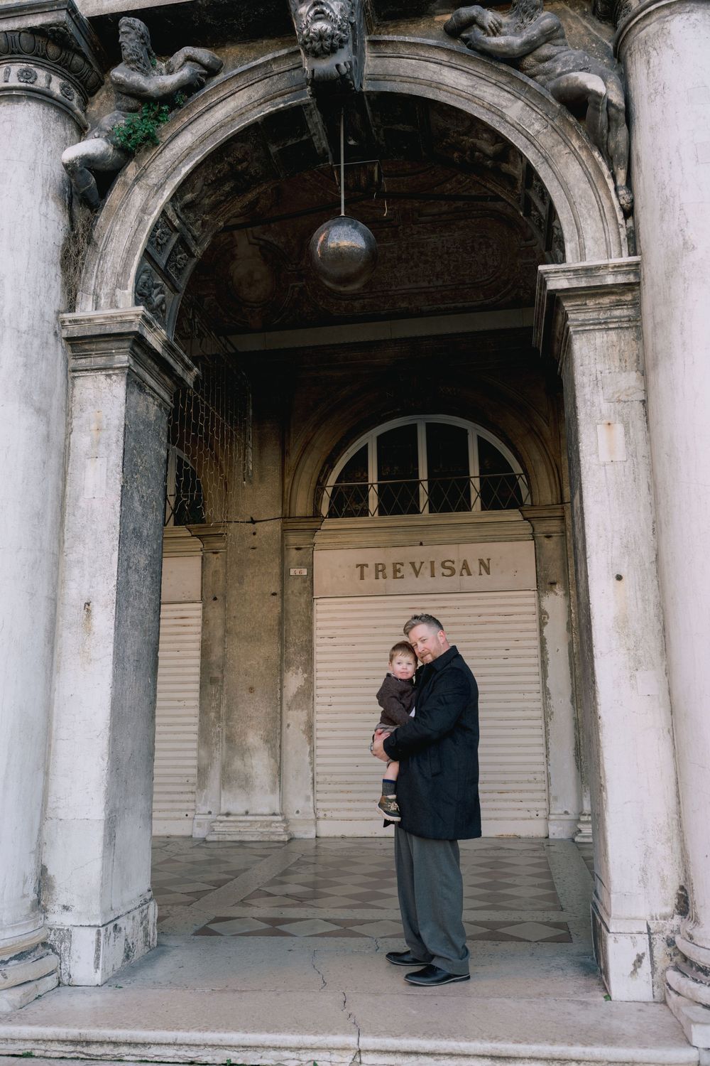 A series of arched columns and storefronts in a historic building. Venice photographer for a family photoshoot.