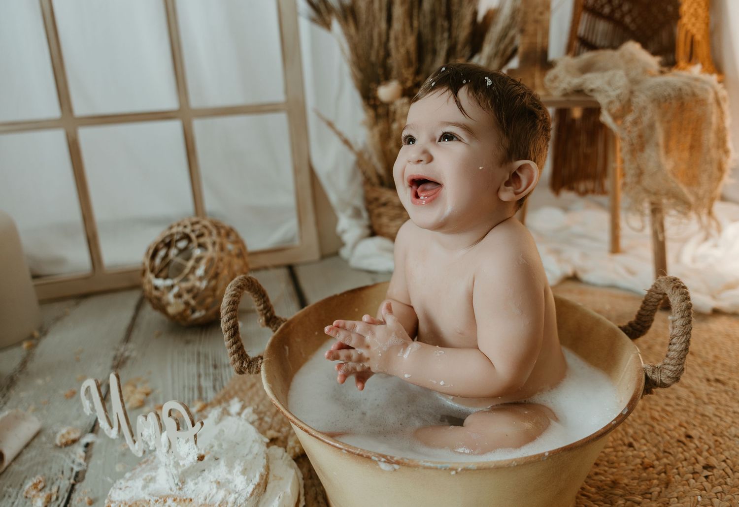 Niña disfrutando del baño y la tarta en su sesión smash cake en Valencia