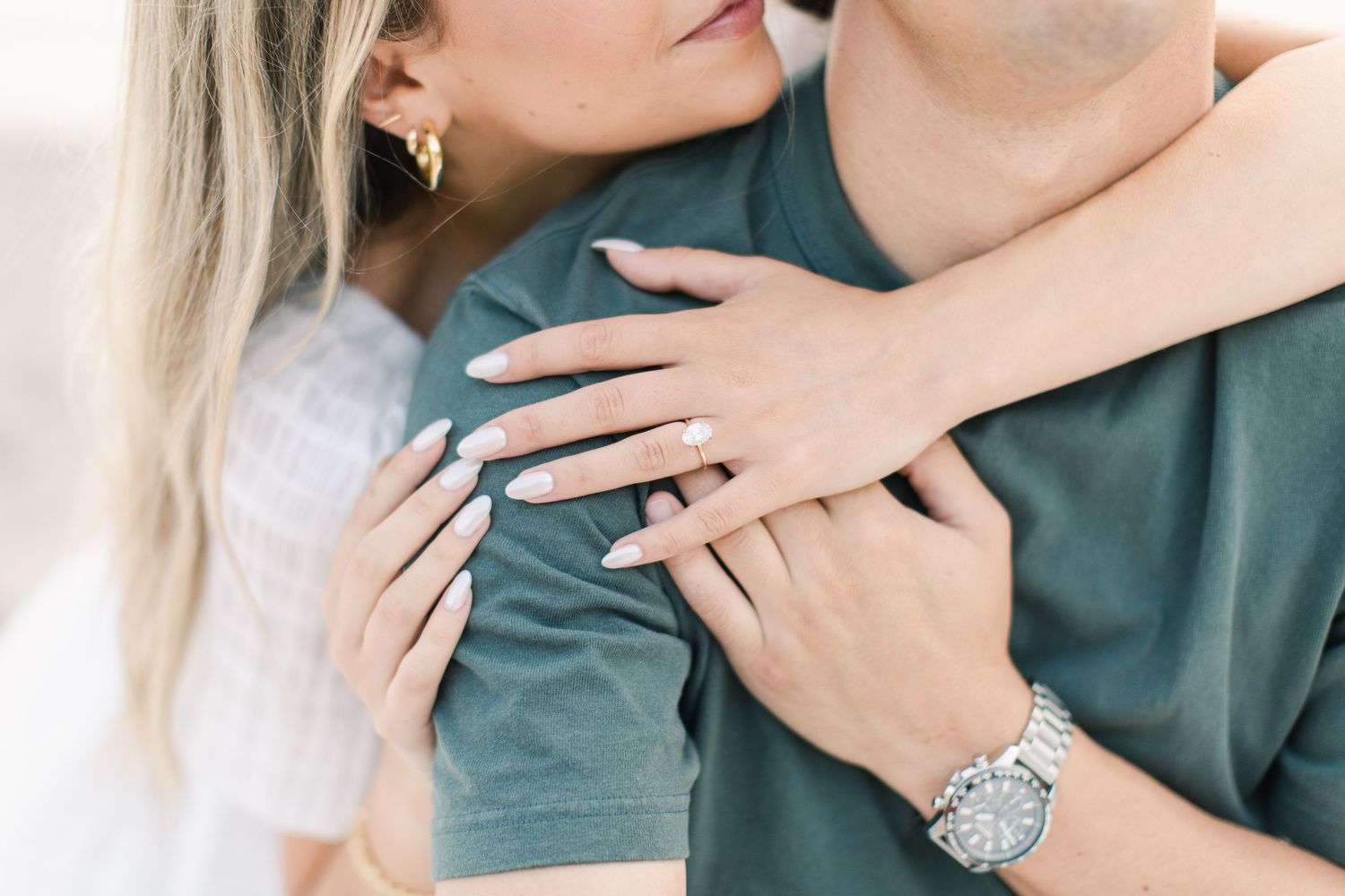 Close up of couple embracing showing hands and wristwatch details.