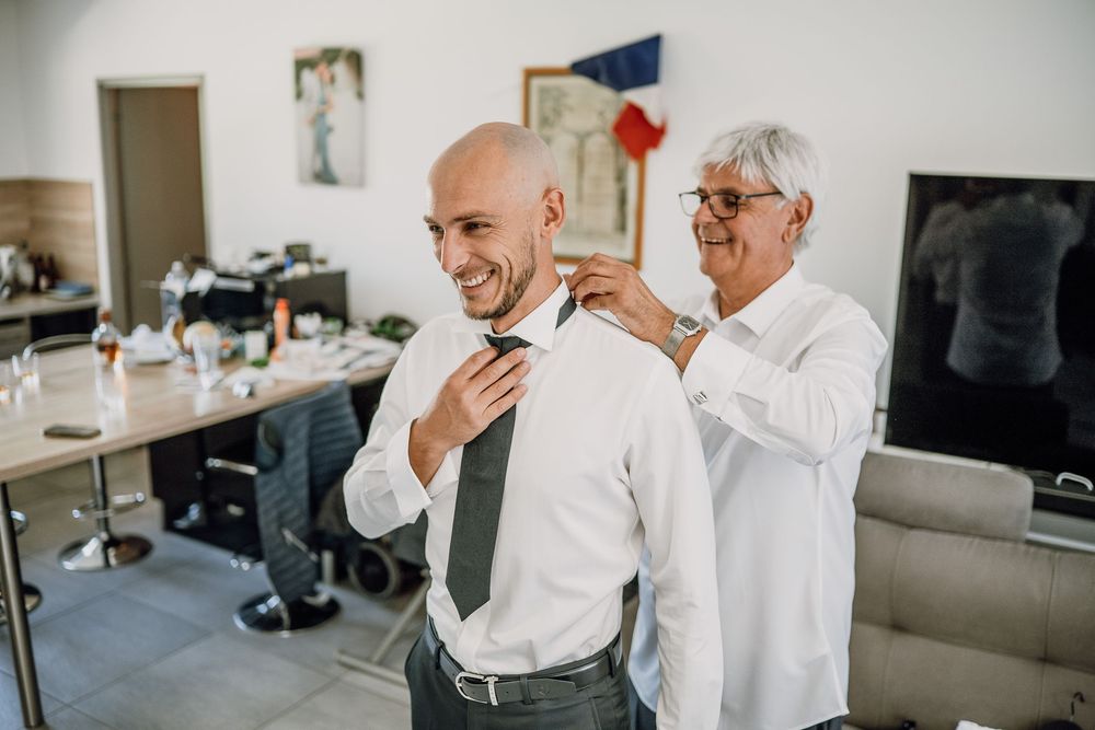 Two people in white shirts share a joyful moment while working in a bright modern office environment.