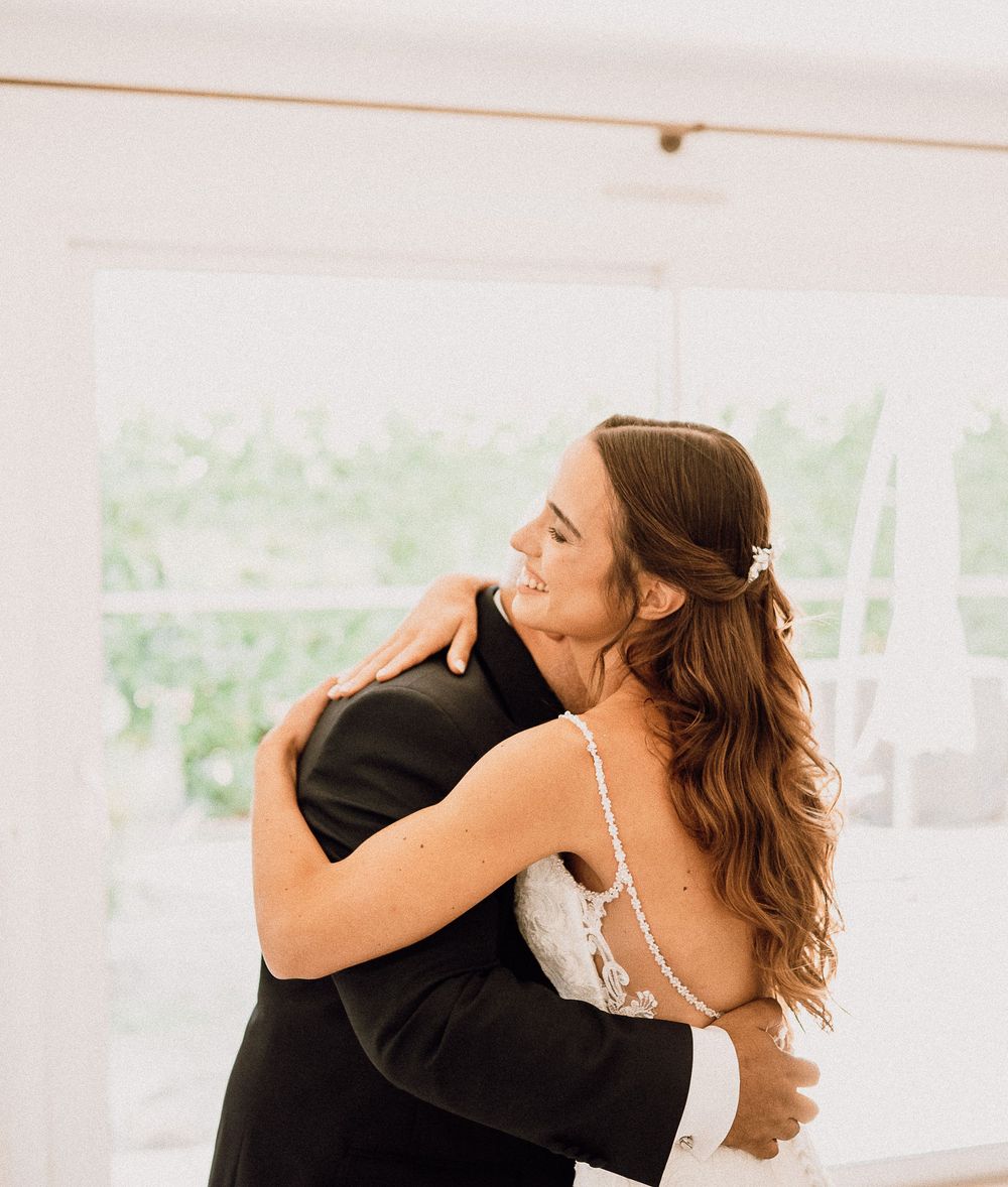 Emotional first look sequence showing couple embracing during wedding day in bright sunlit venue.