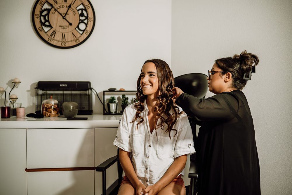 A couple shares a tender moment in front of a vintage clock during their wedding photoshoot.