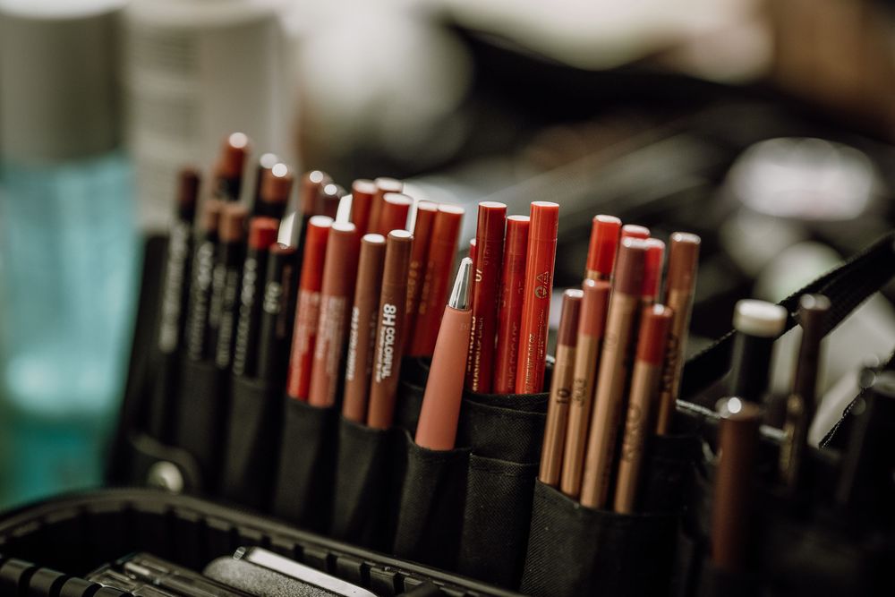Close-up view of makeup products and cosmetics arranged in rows showing various lipsticks and beauty items.