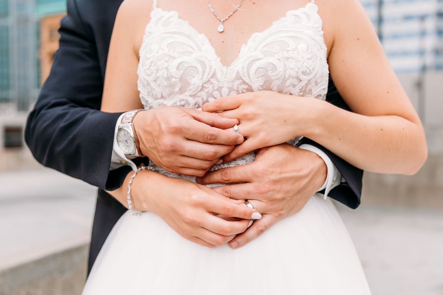 A close-up view of hands wearing wedding rings during an intimate wedding ceremony moment.