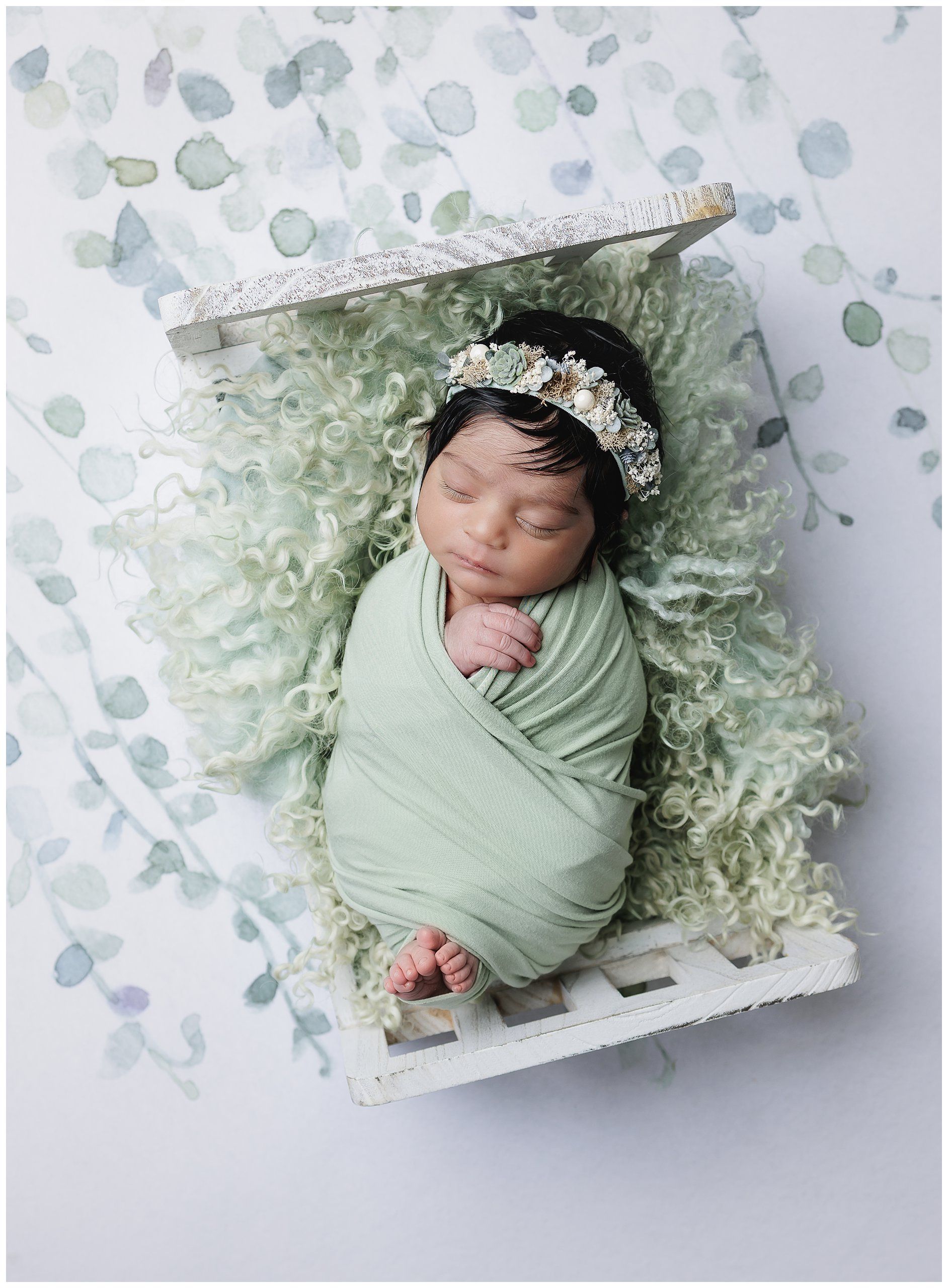Soft neutral newborn photography portrait of baby wrapped in sage green blanket in Austin studio by Valerie Kay Photography