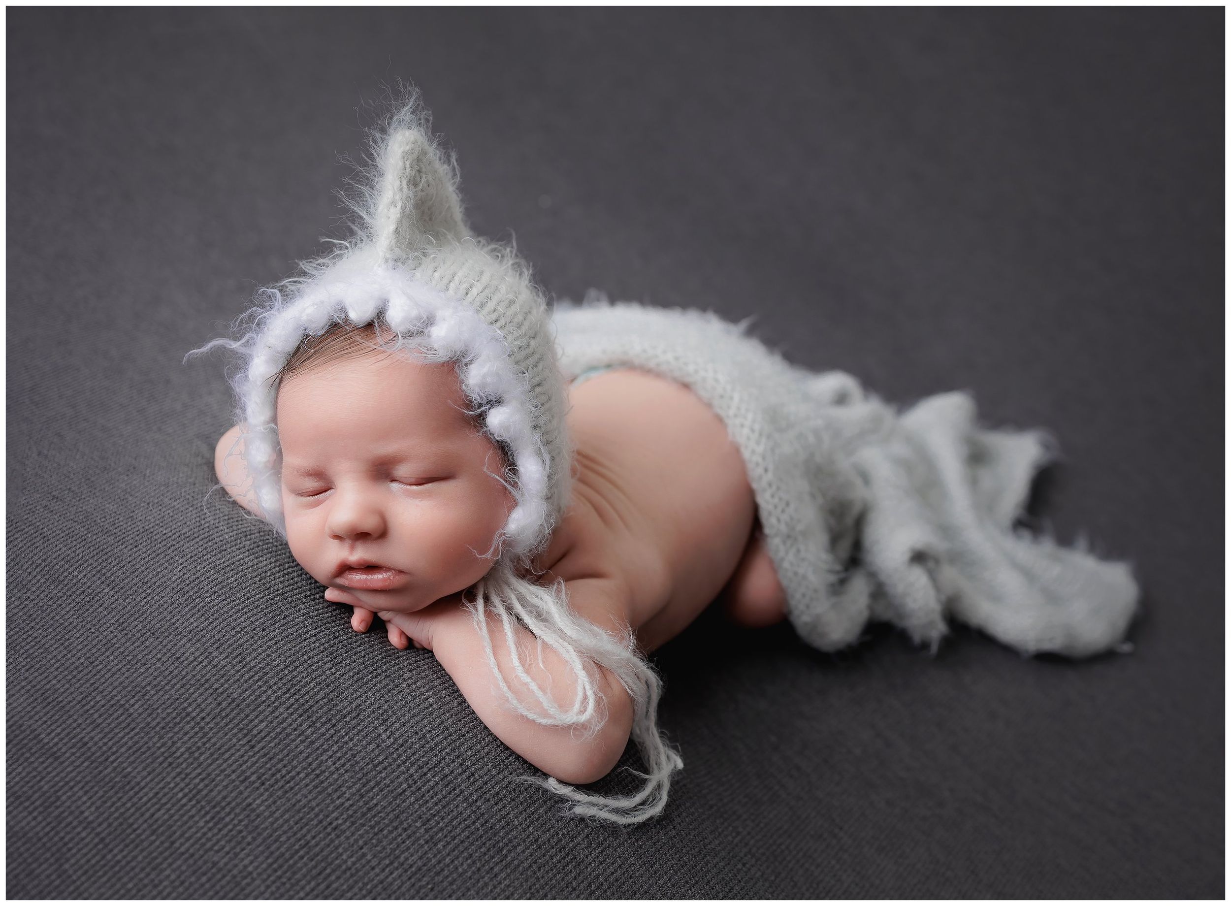 Austin newborn photography studio portrait of sleeping baby wearing white bonnet on dark background by Valerie Kay Photography