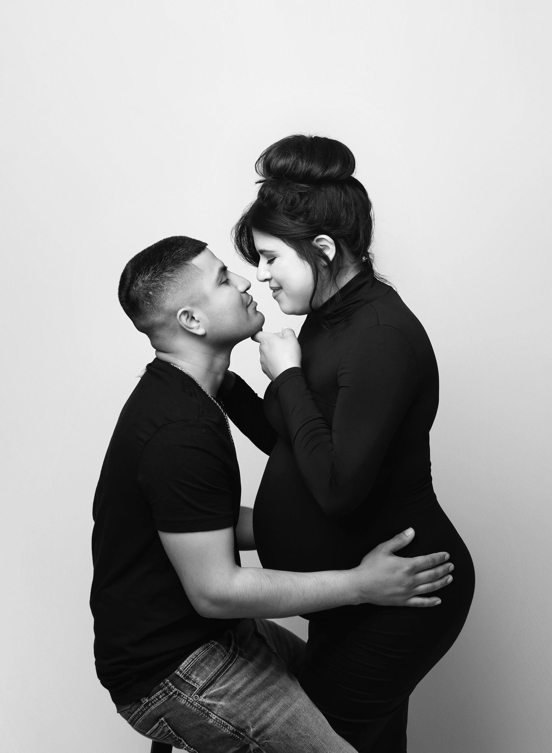 Black and white maternity photography portrait of expecting couple embracing in studio photographed by Valerie Kay Photography Austin