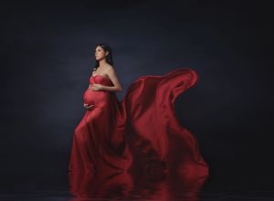 Fine art maternity portrait with dramatic flowing red fabric photographed in Austin studio by Valerie Kay Photography