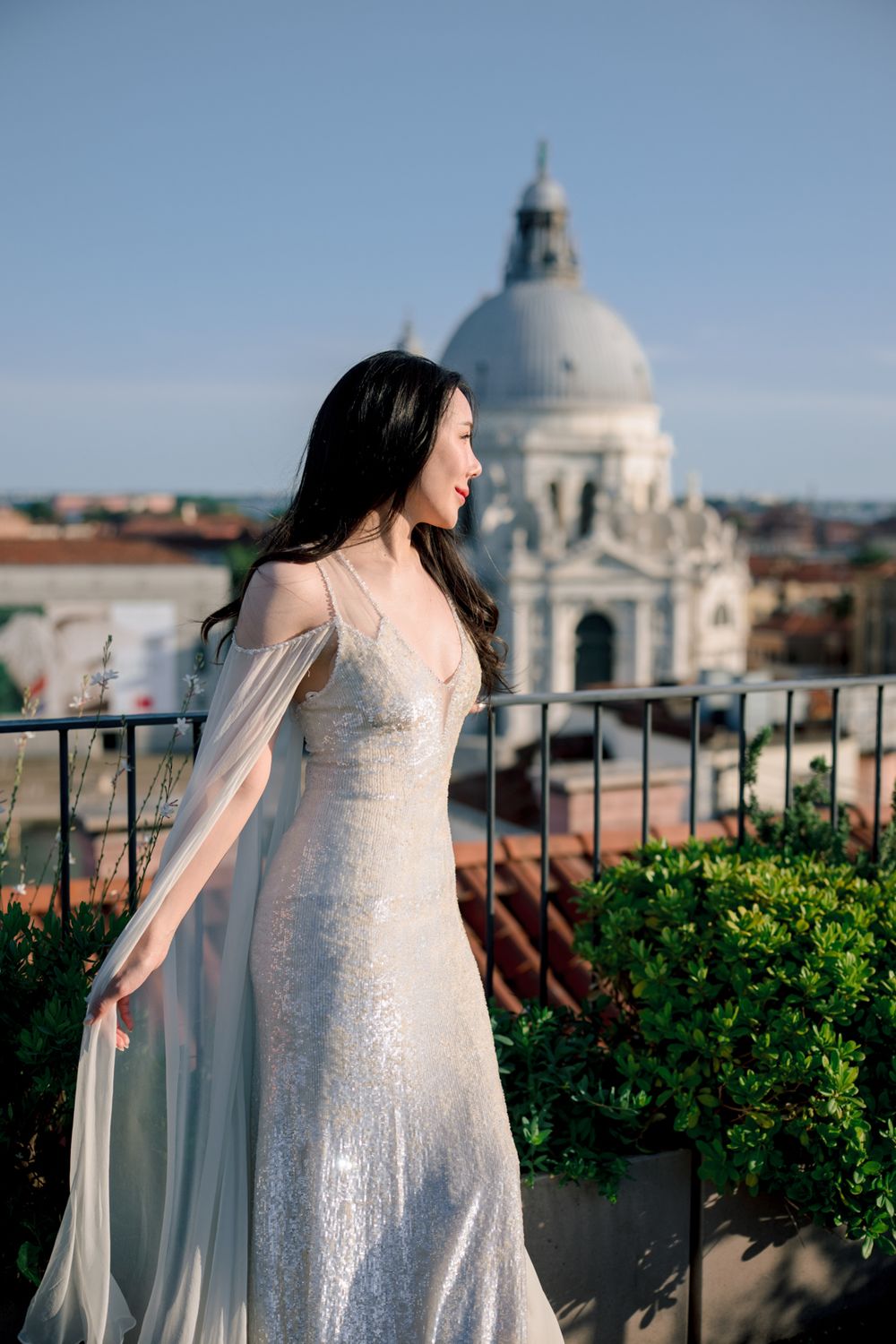Bride in white sequin gown on Venice rooftop terrace with Santa Maria della Salute dome backdrop.