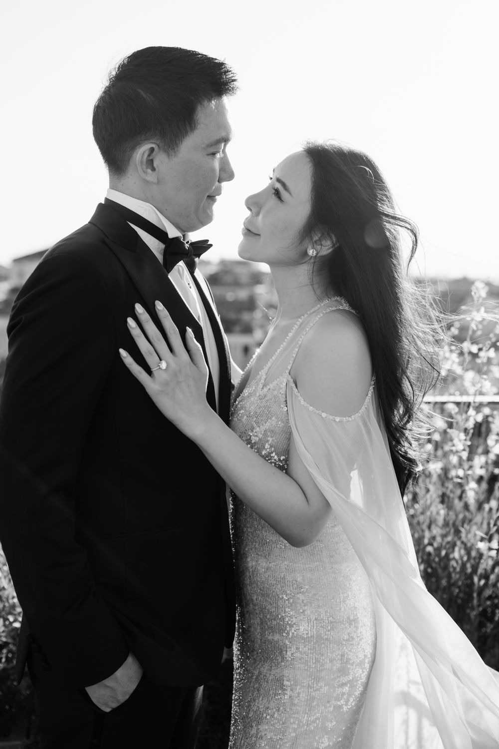 A bride and groom share a romantic moment on a rooftop terrace in Venice, captured in black and white.