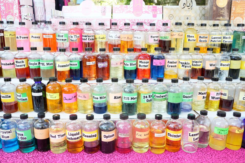 Rows of colorful flavored syrup bottles displayed at an outdoor vendor booth.