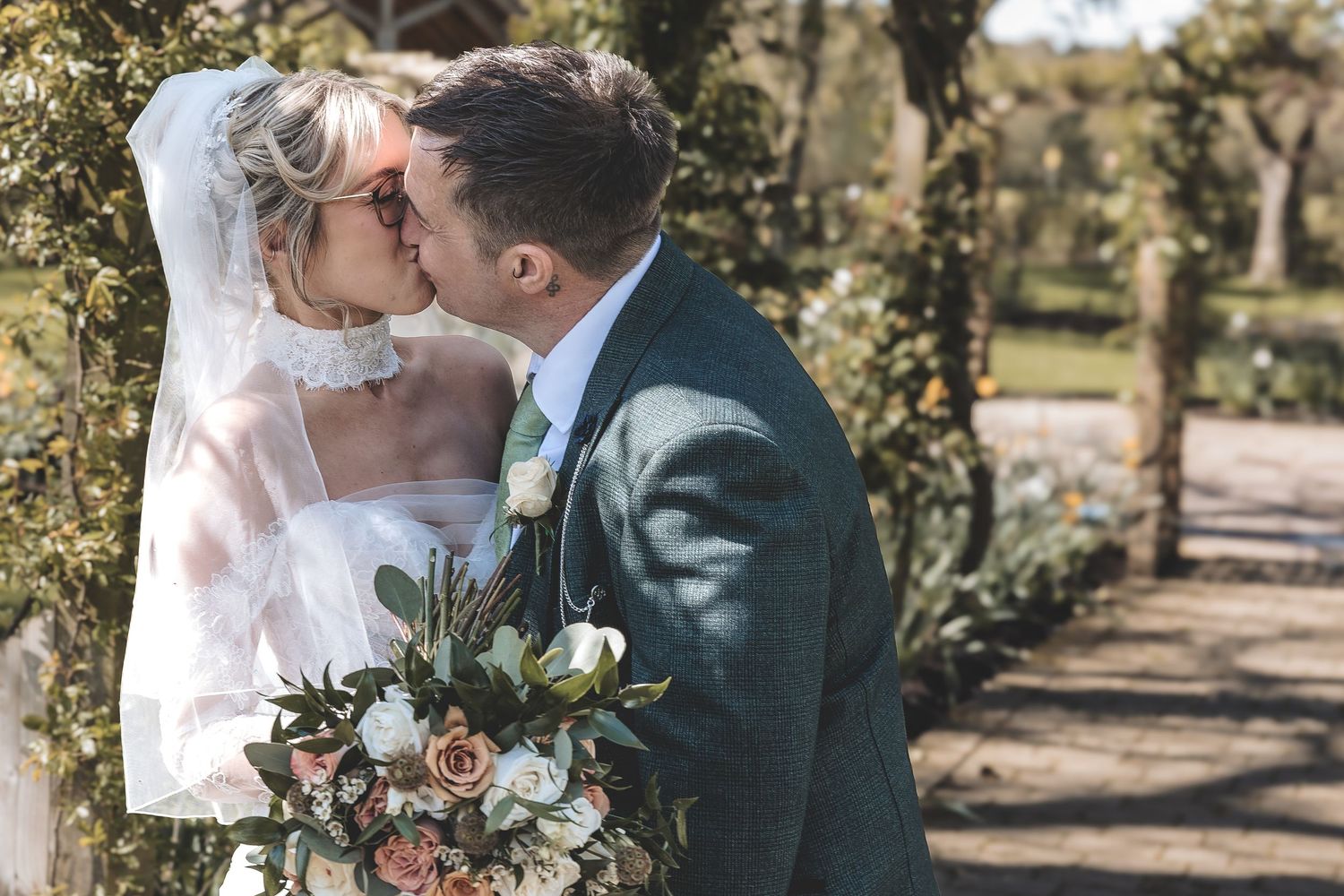 Natural fun kiss between a couple during their relaxed couple photos at their wedding venue.