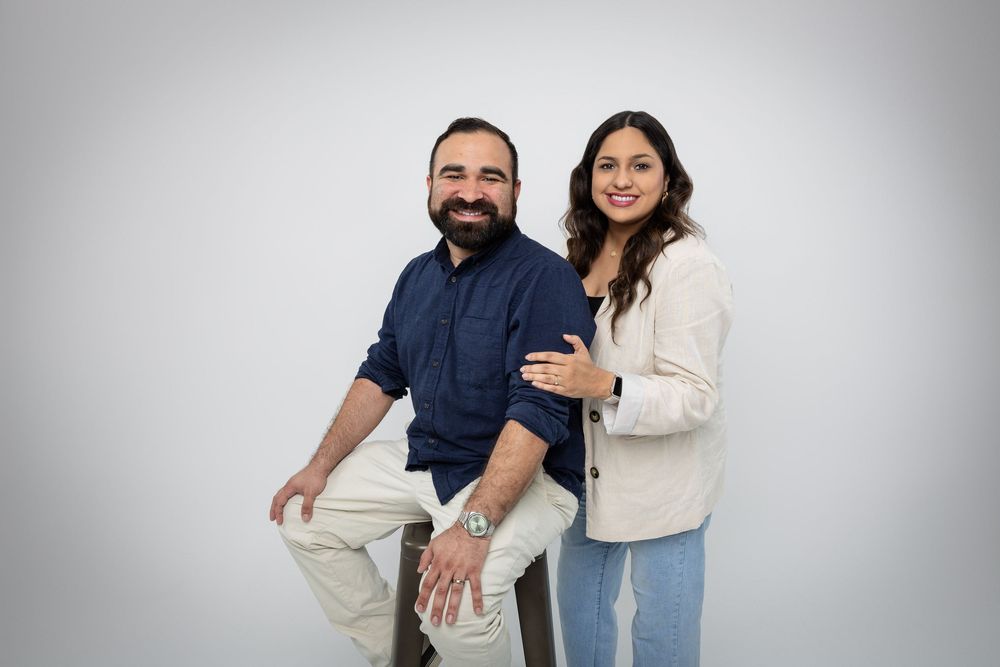 Romantic studio portraits of couple in navy and cream colored outfits showing affection.