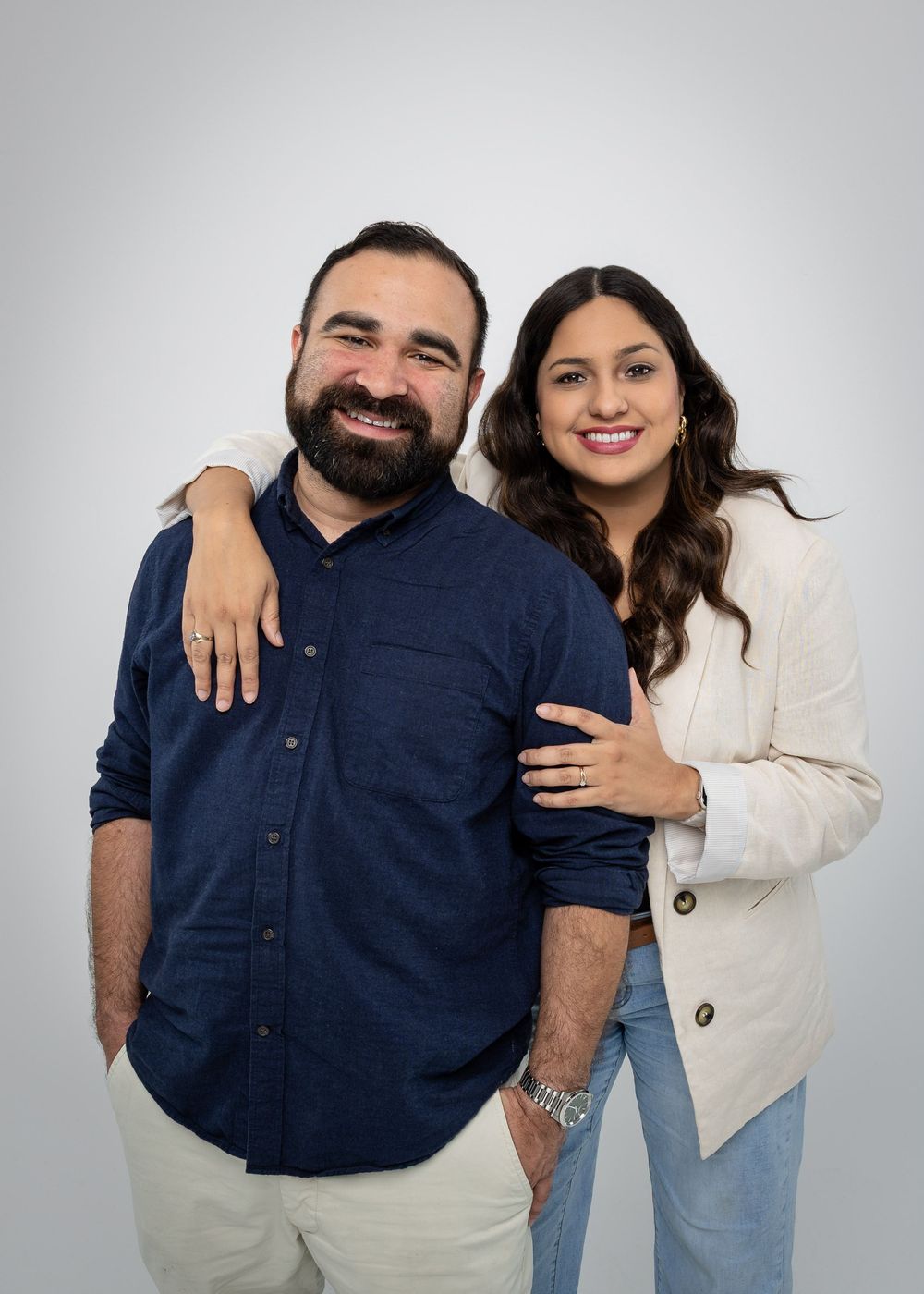 Studio portrait series showing couple in navy and white clothing with natural expressions.