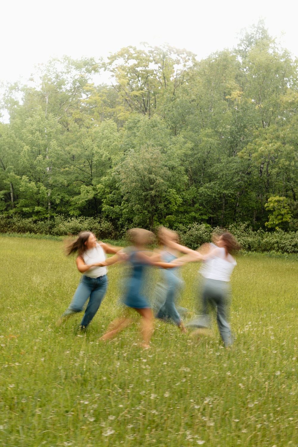 Children playing ring-around-the-rosie in a green meadow, motion blur capturing their joyful spinning dance outdoors.