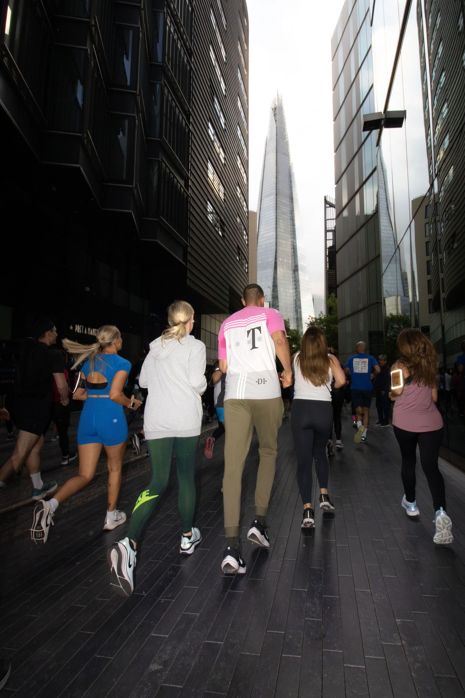 Group of runners jogging through urban cityscape with the Shard in background.