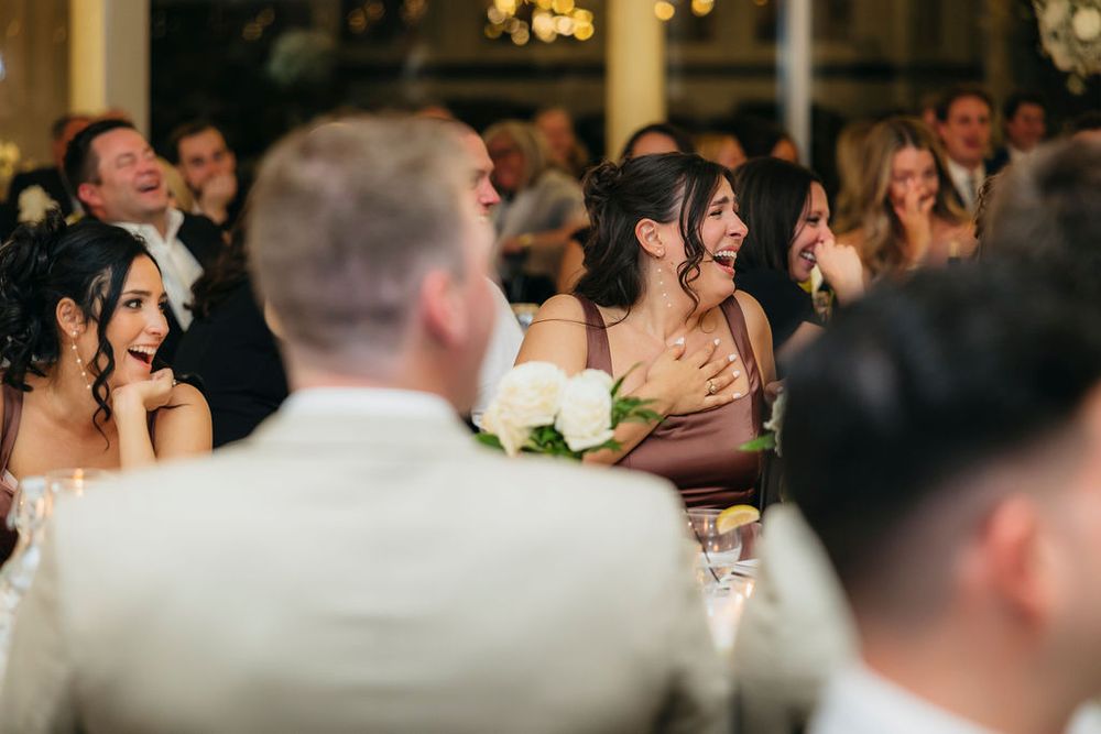 Guests laughing and reacting emotionally during wedding reception speeches at elegant Meson Sabika venue in Naperville, IL