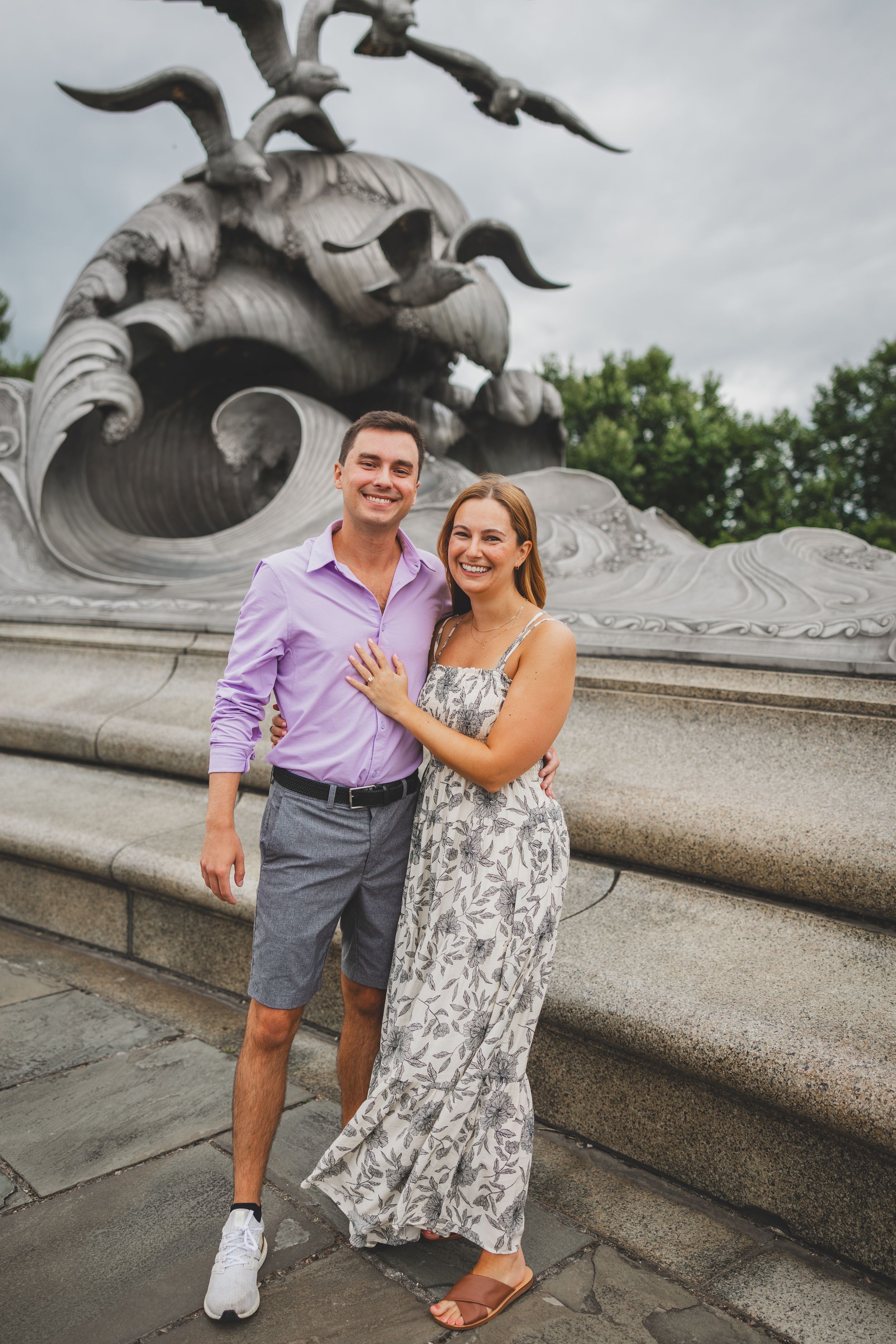 Happy couple posing in front of ornate stone fountain sculpture in Central Park, New York.