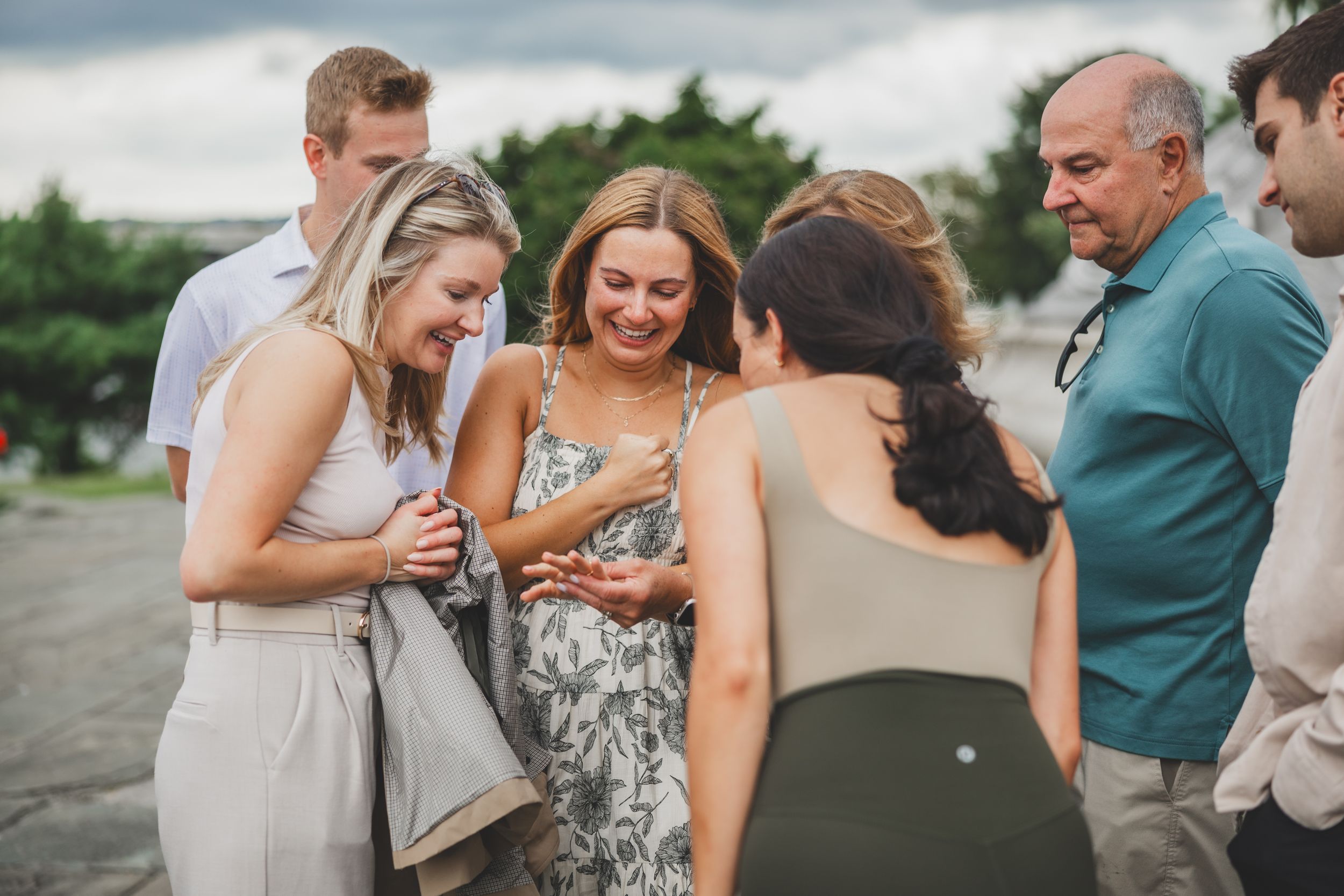 Group of friends laughing and sharing a joyful moment outdoors at a casual beach gathering.