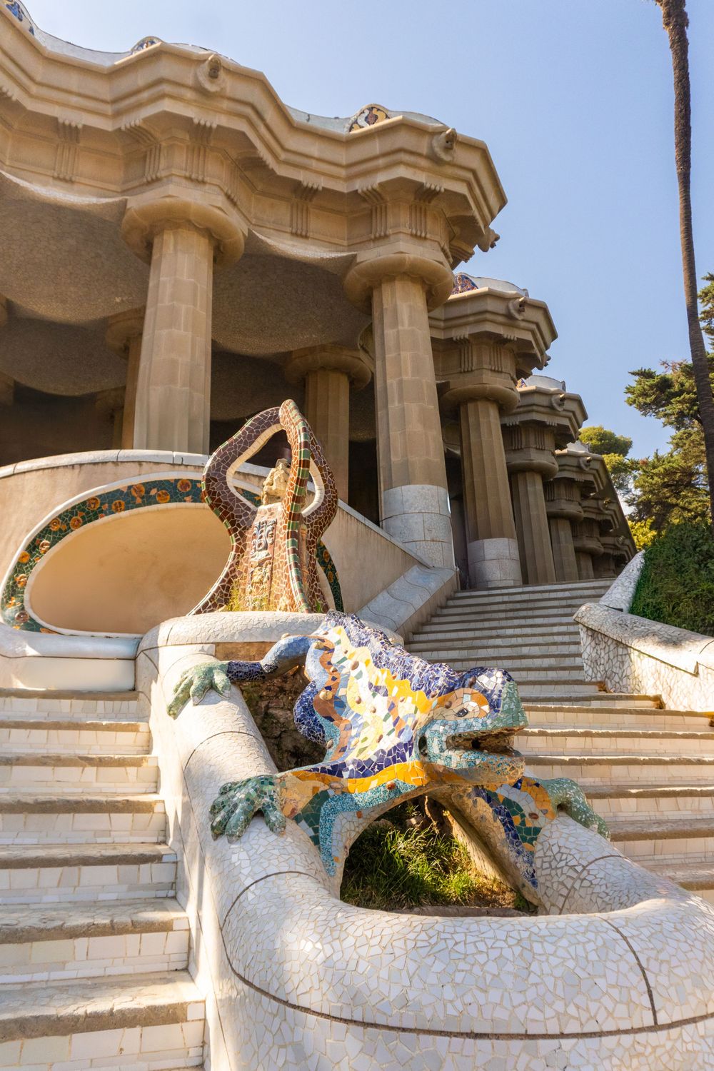 Mosaic lizard sculpture on white stairs at Park Guell in Barcelona.