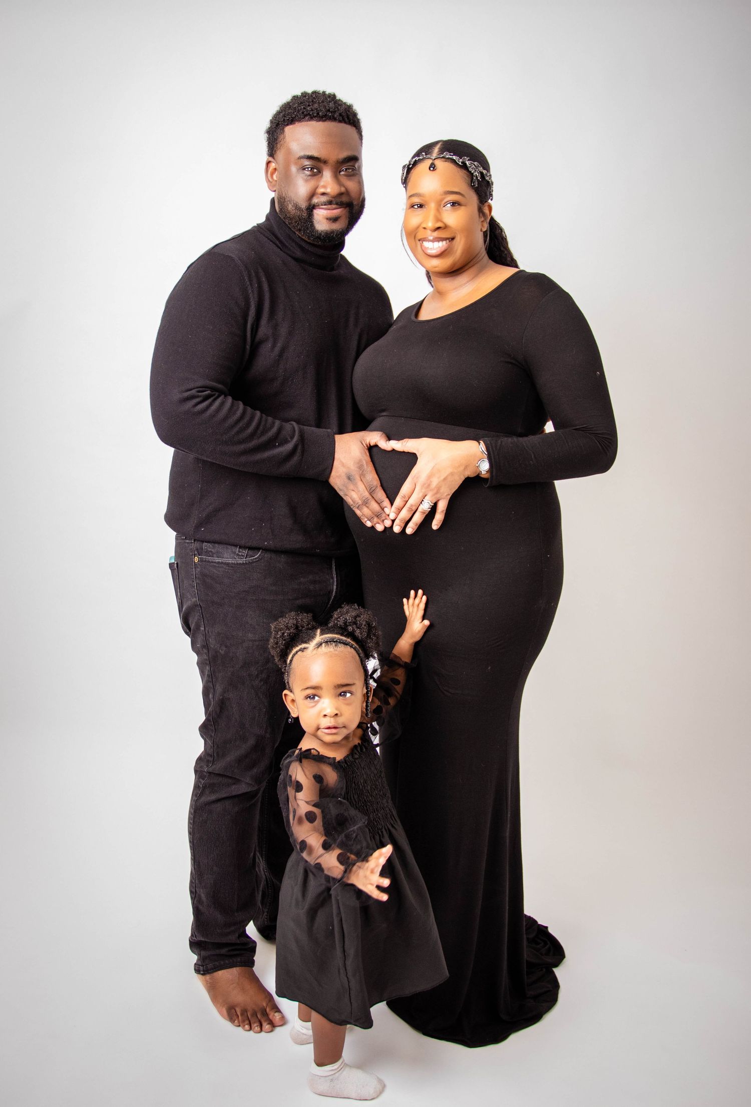 Joyful family studio portraits with matching black attire.