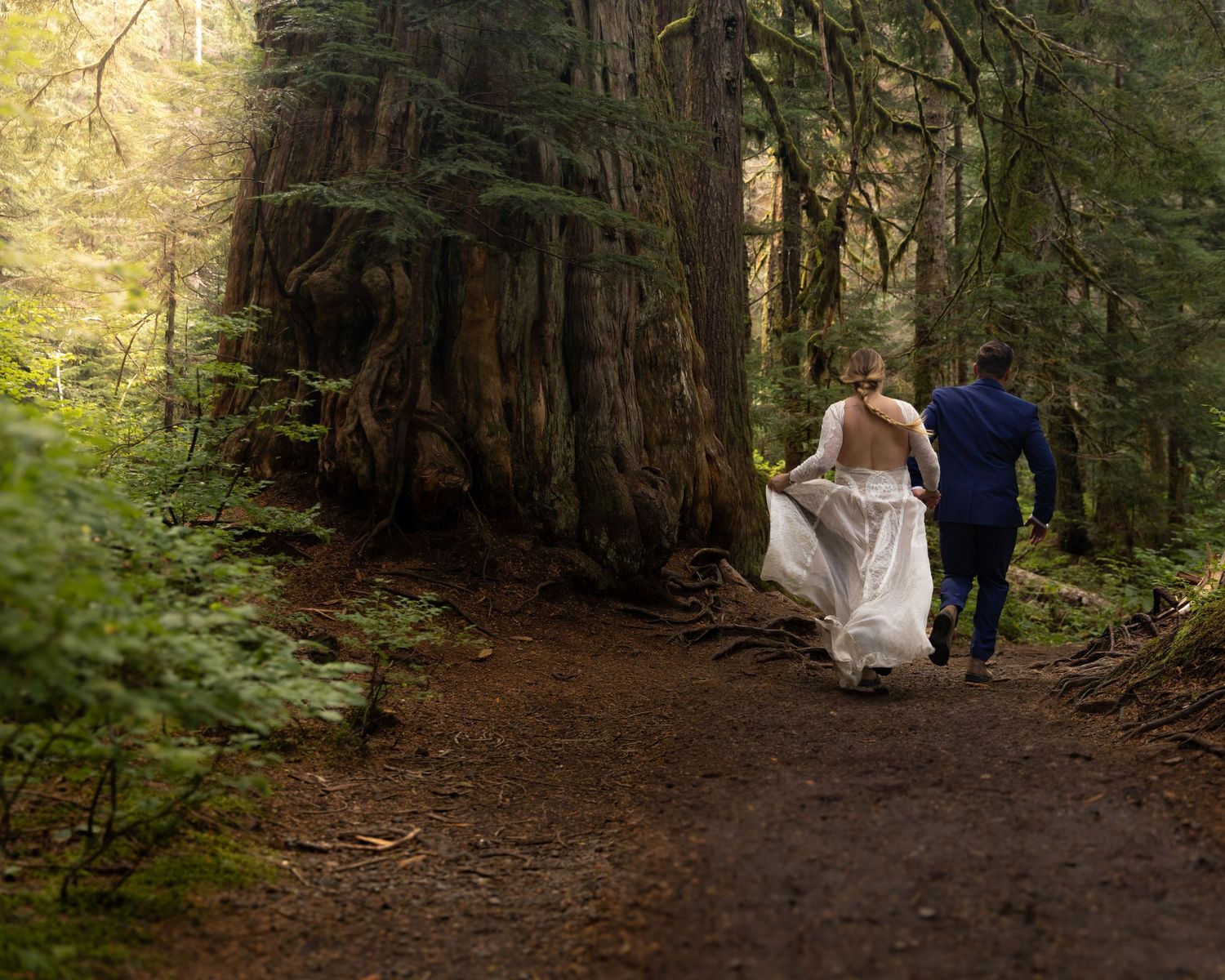 Erin and Charlie run through the forest during their Washington Elopement.