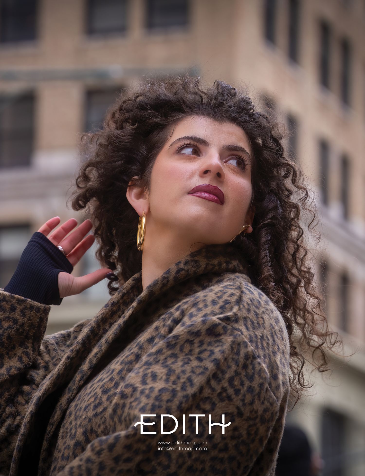 Editorial fashion photo showcasing leopard print coat and gold jewelry in urban setting.