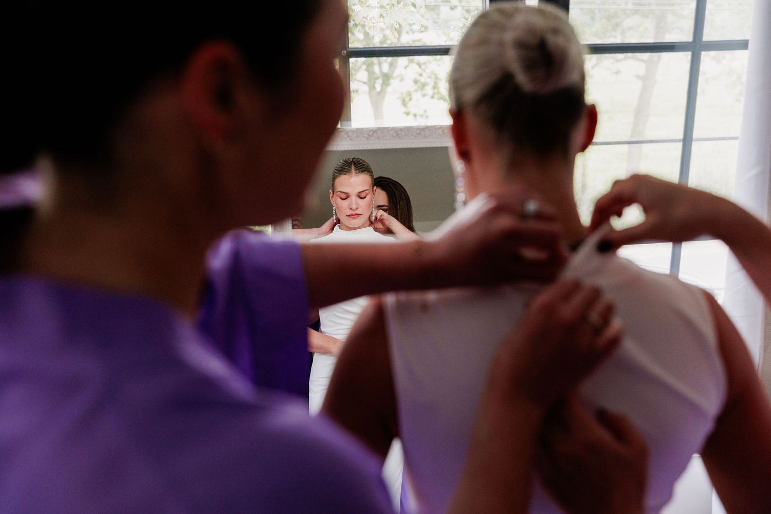 Wedding celebration captured through window reflections in an indoor setting.