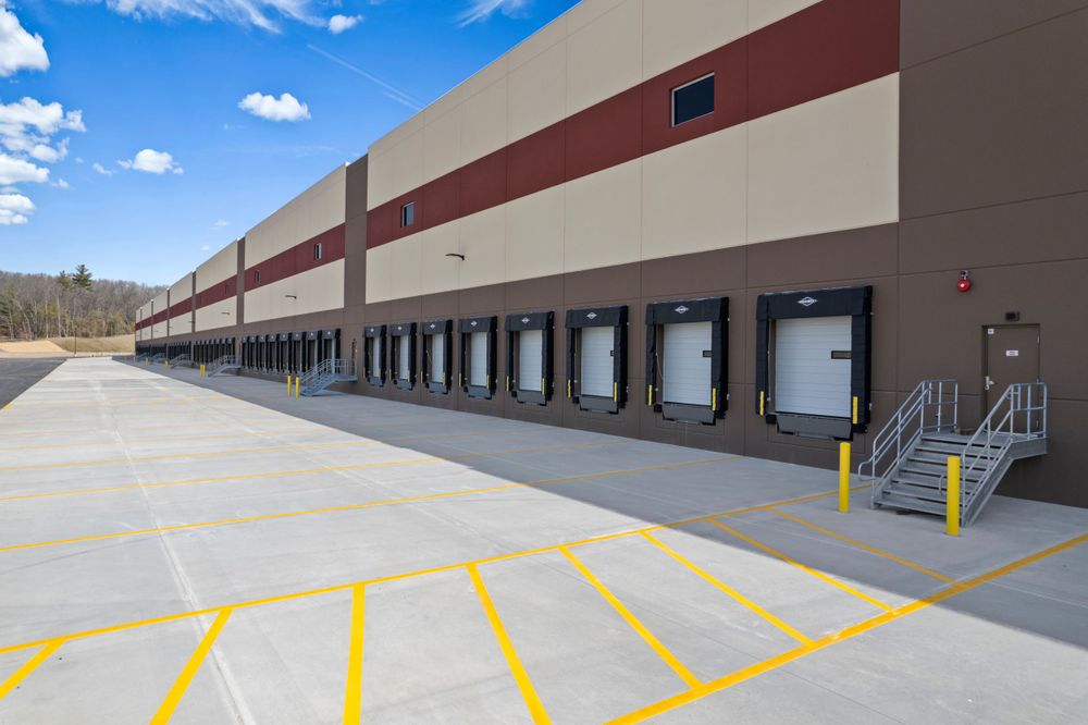 Row of loading dock bays at modern industrial warehouse facility with painted yellow safety lines.