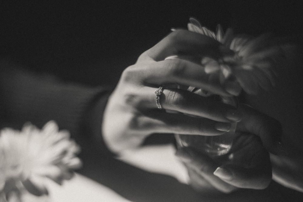 Artistic black and white close-up of hands in gentle motion.