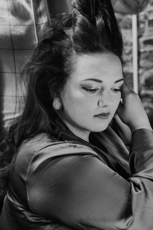 A dramatic black and white portrait showing elegant makeup and jewelry styling.
