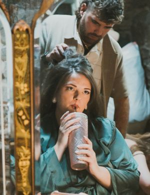 A retro-styled scene showing someone sipping from a milkshake while getting their hair styled.
