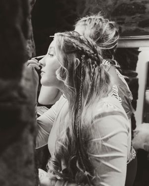 Black and white photo of intricate braided hairstyle being styled for special occasion.