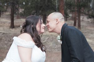 A tender moment between newlyweds as they share a close embrace outdoors.