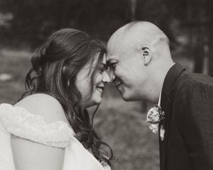 An intimate moment shared between a couple in wedding attire outdoors.