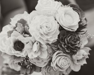 Black and white photograph of an elegant wedding bouquet featuring roses, anemones and delicate filler flowers.