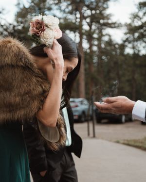 Close-up of hands offering a delicate bouquet of pink and white roses.
