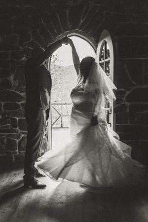 A silhouetted couple in a stone archway creating a dramatic black and white wedding photo.